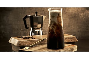 Hoshizaki crescent ice melts in a tall glass of iced coffee topped with cream