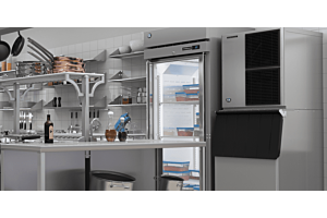 A commercial kitchen scene featuring a Hoshizaki Modular Crescent Cuber ice machine stacked on a matching bin next to a glass-door reach-in refrigerator