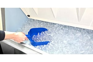 Hand scooping clear ice from a Hoshizaki commercial ice storage bin