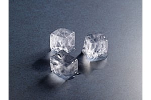Three clear, square Hoshizaki ice cubes melting on a metallic surface