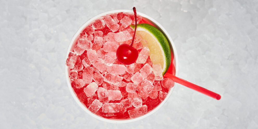 Overhead view of a red beverage filled with Hoshizaki Cubelet ice, garnished with a cherry and a lime slice
