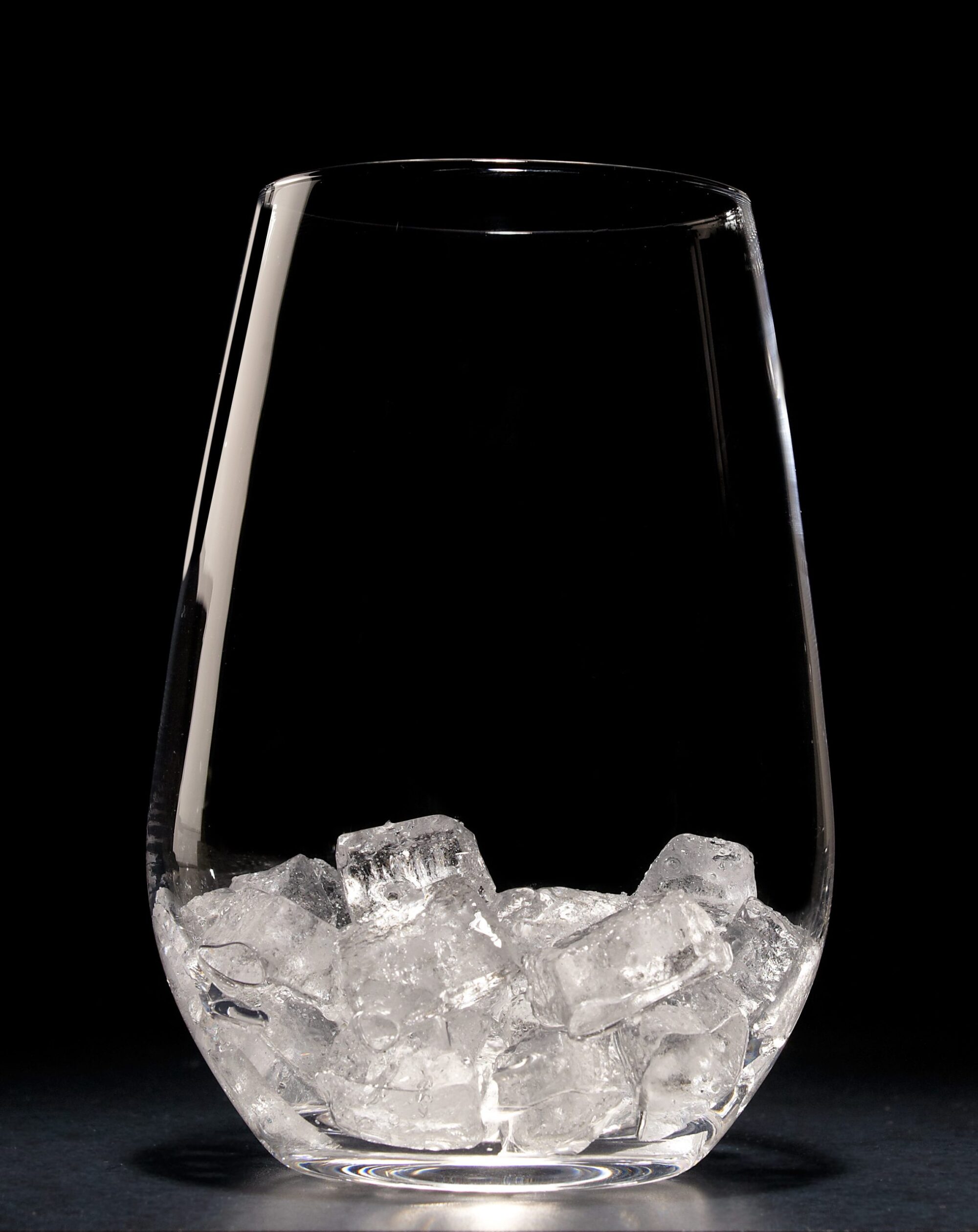 Clear glass tumbler containing Hoshizaki Cubelet ice against a stark black background