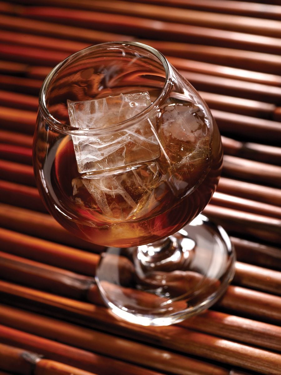 Overhead view of a glass containing a dark beverage and large, clear Hoshizaki square ice cubes